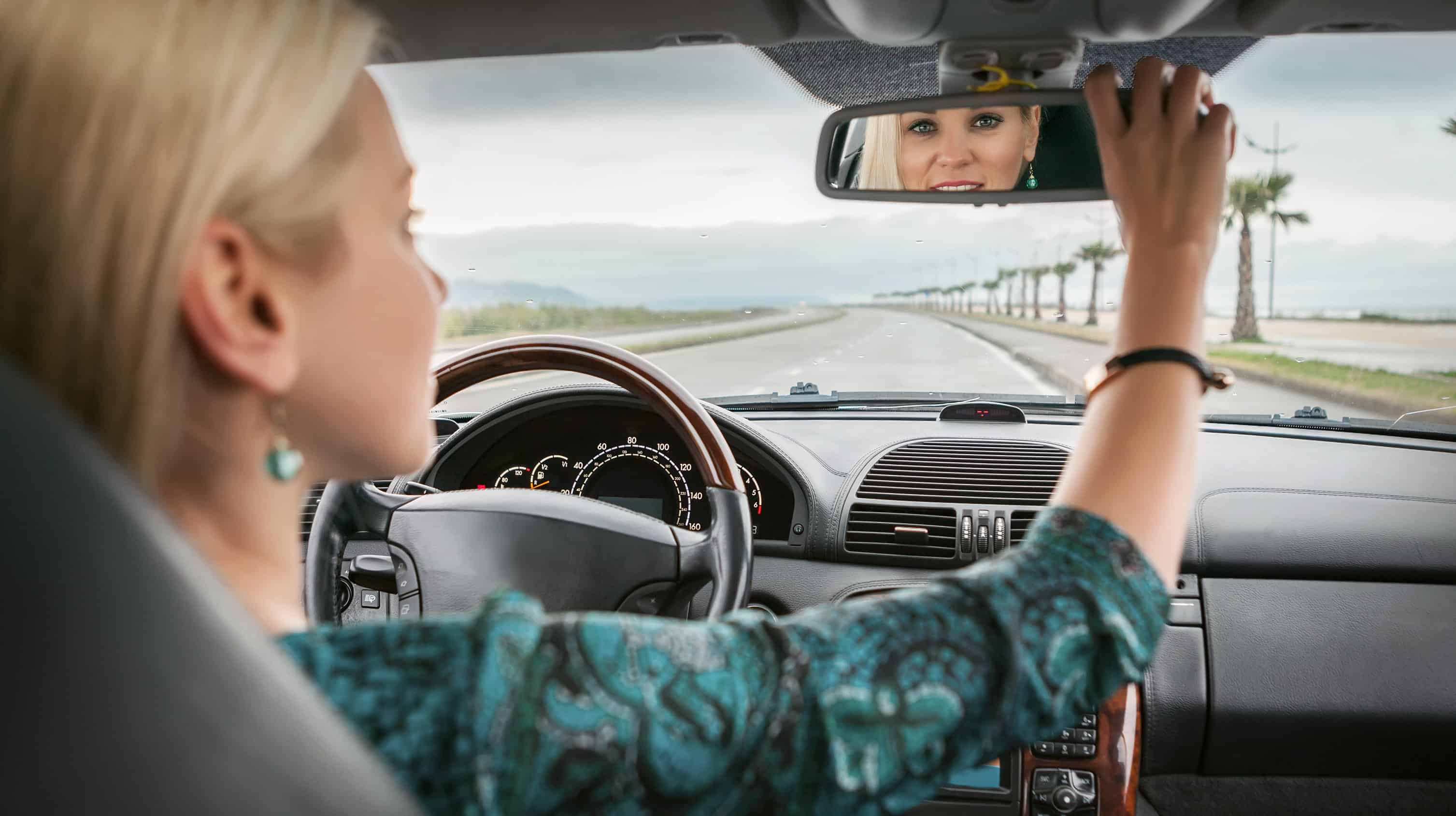 Водитель смотрит в зеркало. Девушка в зеркале машины. Женщина зеркало автомобиль. Девушка в зеркале машина блондинка. Девушка смотрит в зеркало в машине.